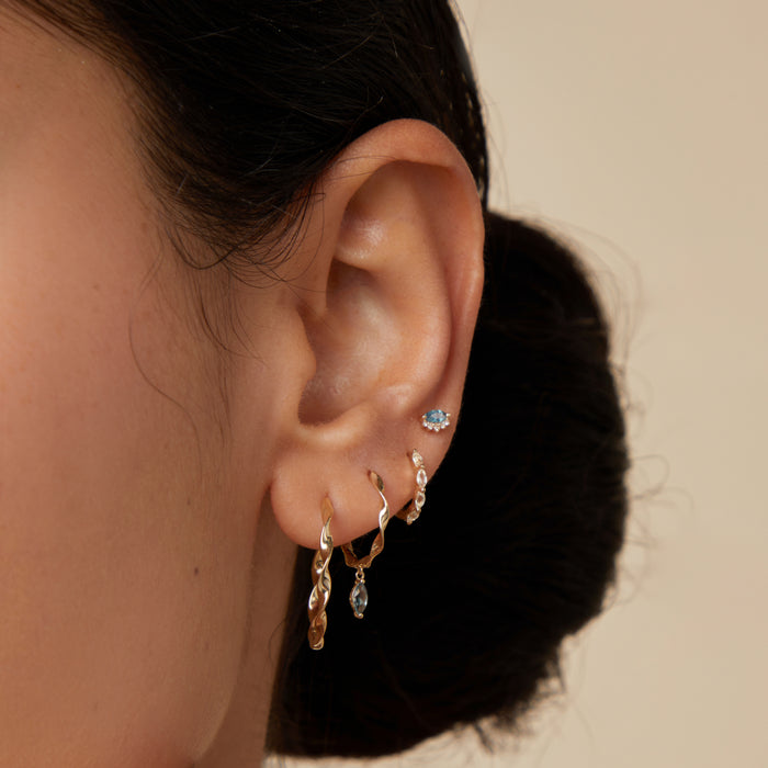 Worn shot of three gold lobe ear jewellery