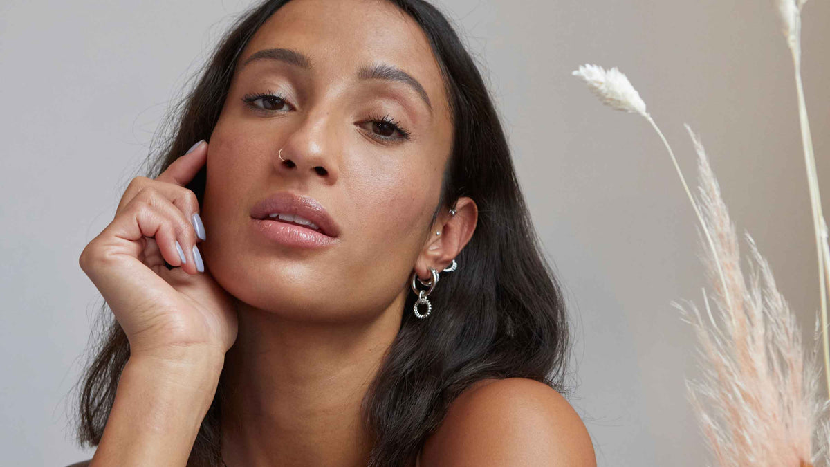 Model trägt mehrere Ohrringe der Gaea Kollektion.