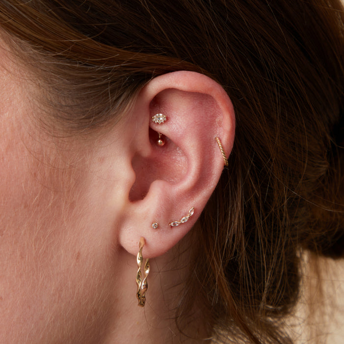 Worn shot of Rook Wave Gold Piercing Jewellery