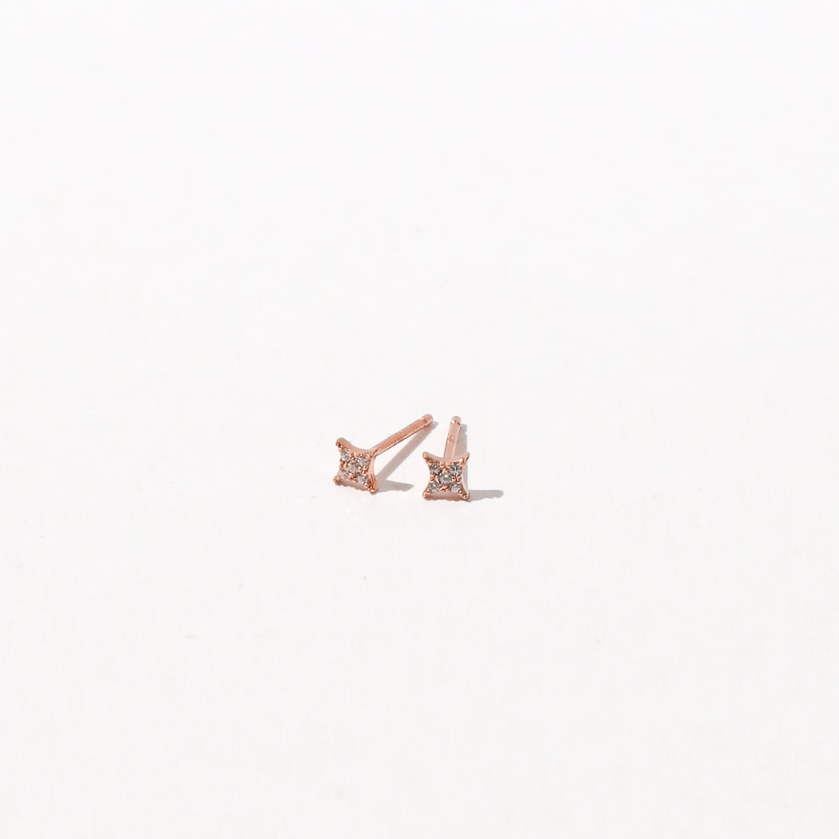 Cosmic Star Crystal Stud Earrings in Rose Gold flat lay