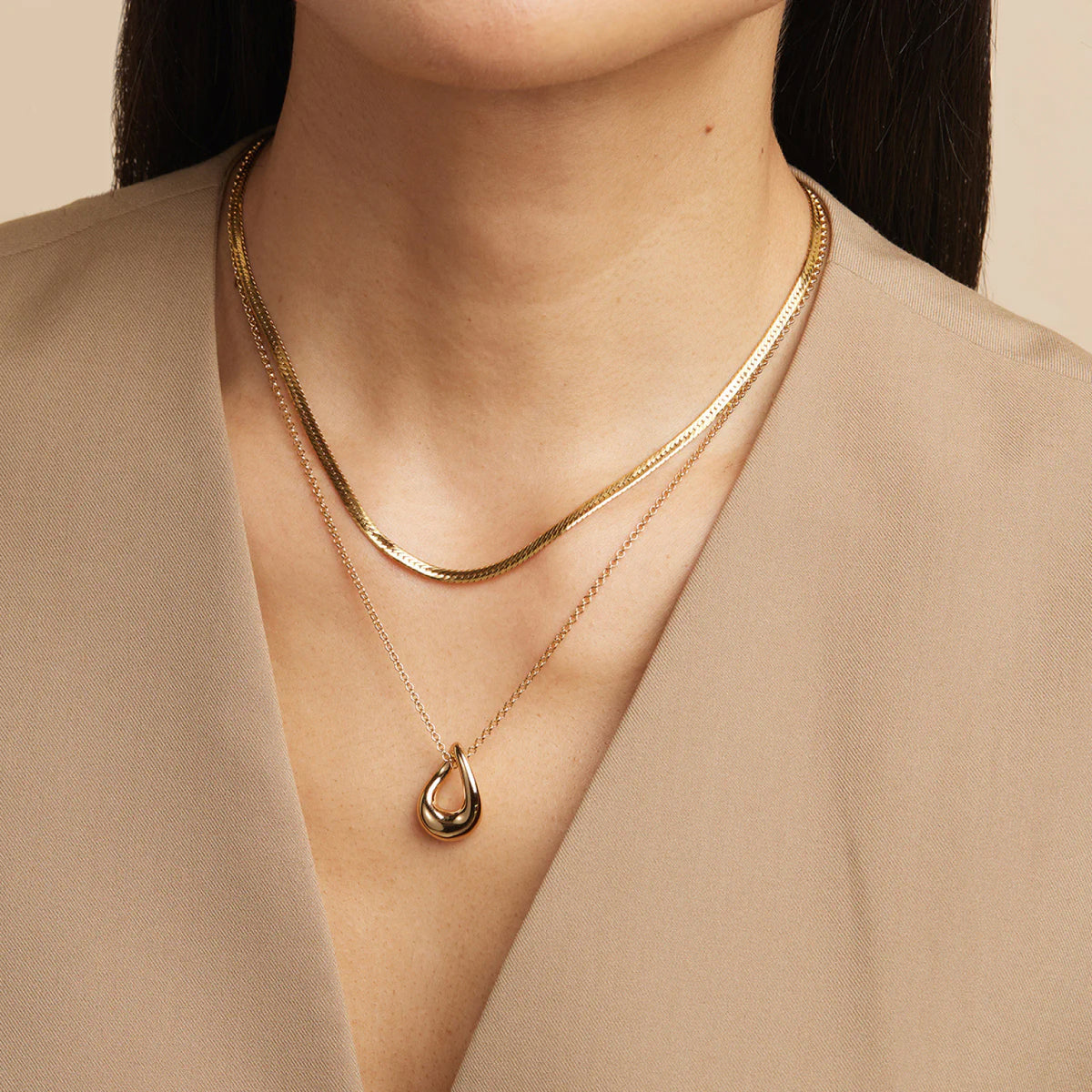 Woman wearing a minimalist silver snake chain with a silver necklace pendant for a simple yet elegant look.
