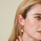 Wave Crystal Ear Cuff in Gold worn with Wave Crystal Ear Huggie and Pearl Charm Hoops