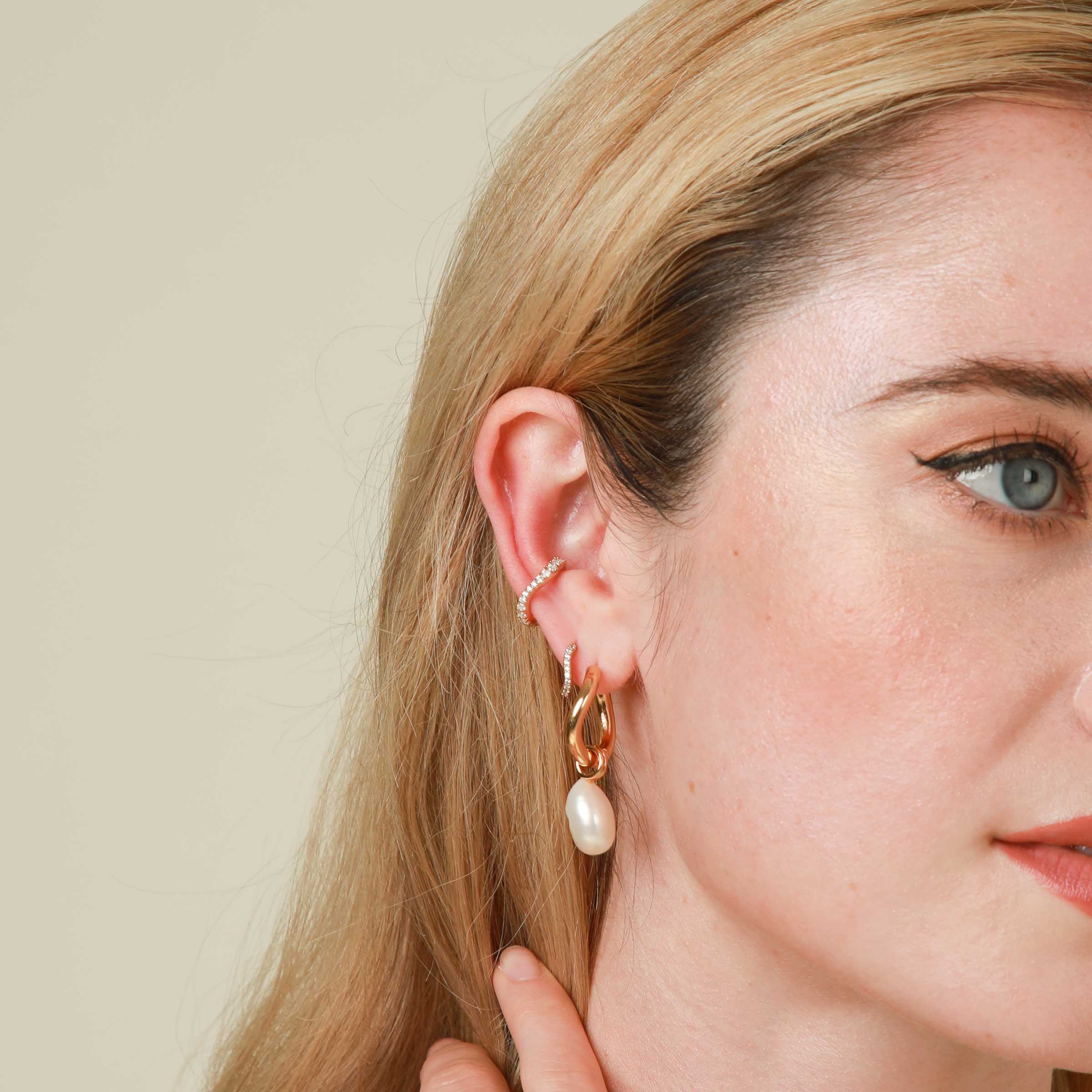 Wave Crystal Ear Cuff in Gold worn with Wave Crystal Ear Huggie and Pearl Charm Hoops
