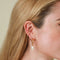 Wave Crystal Huggies in Gold worn with Pearl Charm Hoop and Wave Crystal Ear Cuff