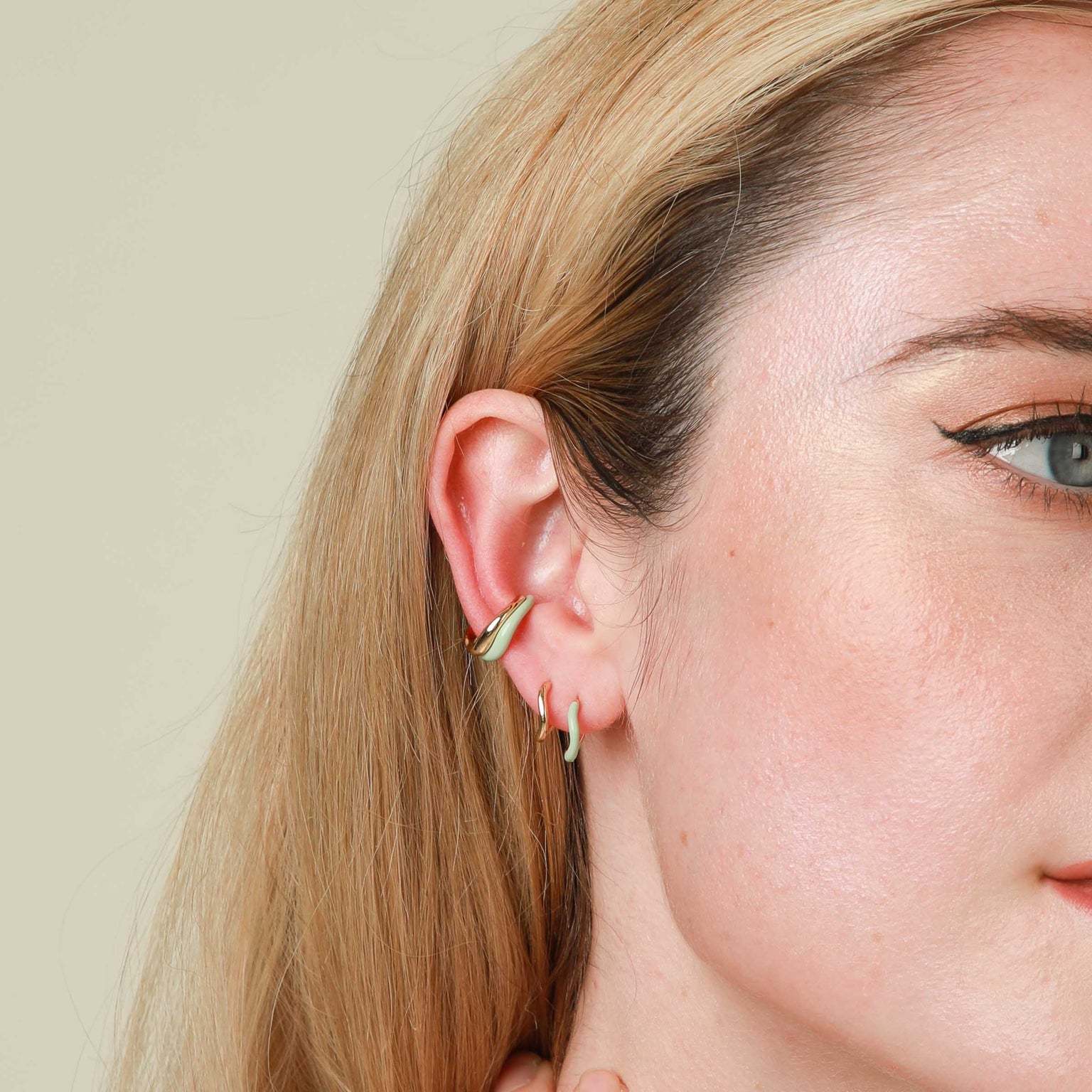 Wave Huggies in Gold worn in upper lobe piercing with Mint Enamel Wave Huggies and Gold & Mint Wave Ear Cuffs