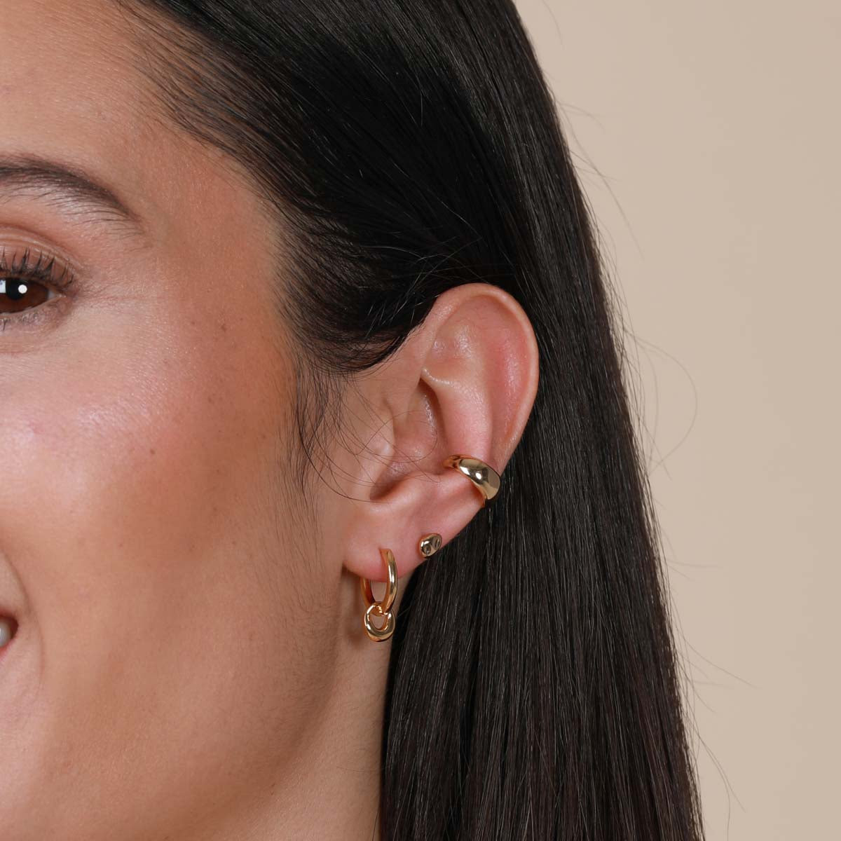 Worn shot of Molten Charm Hoops in Gold in front lobe piercing location