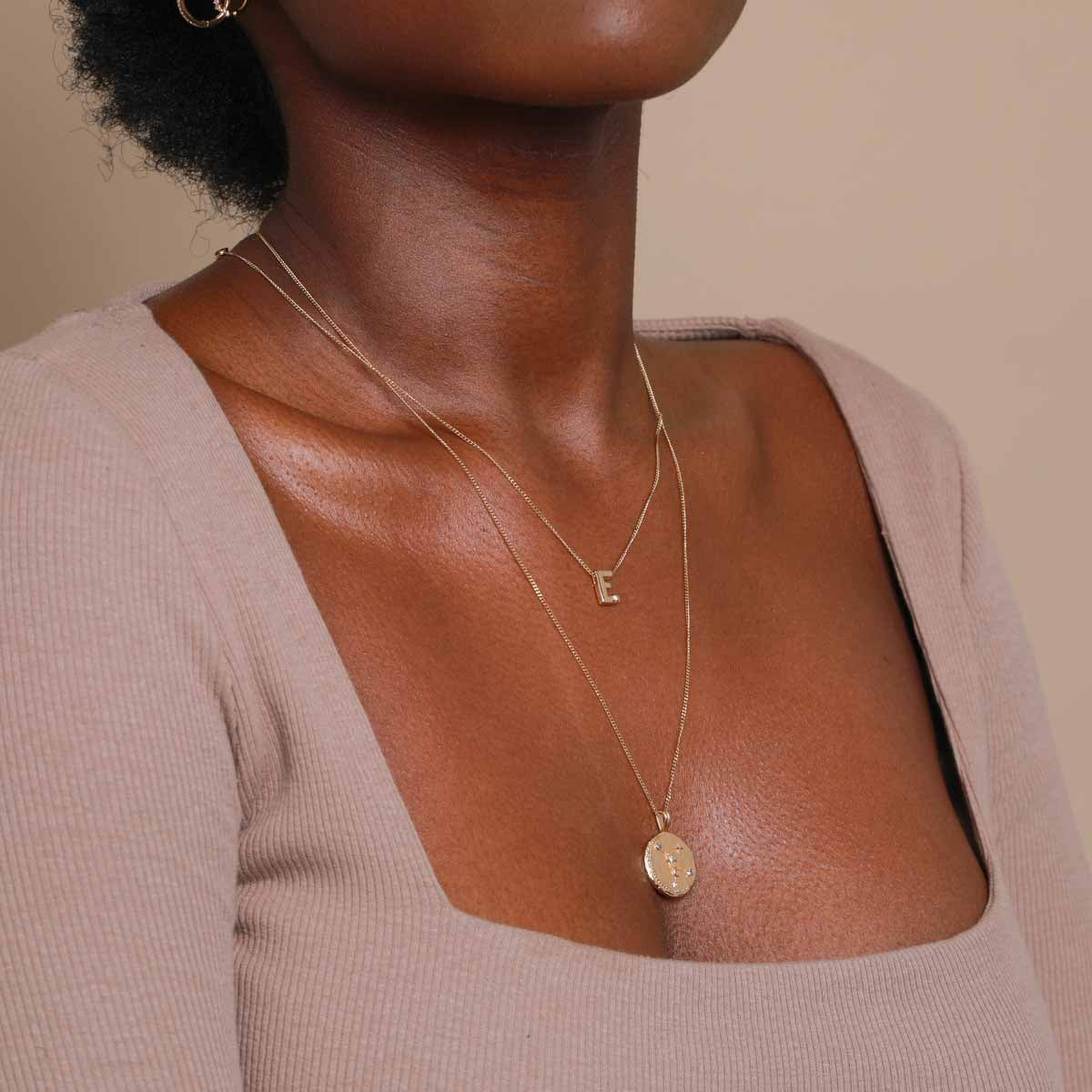 E Initial Pendant Necklace in Gold worn with Zodiac pendant necklace
