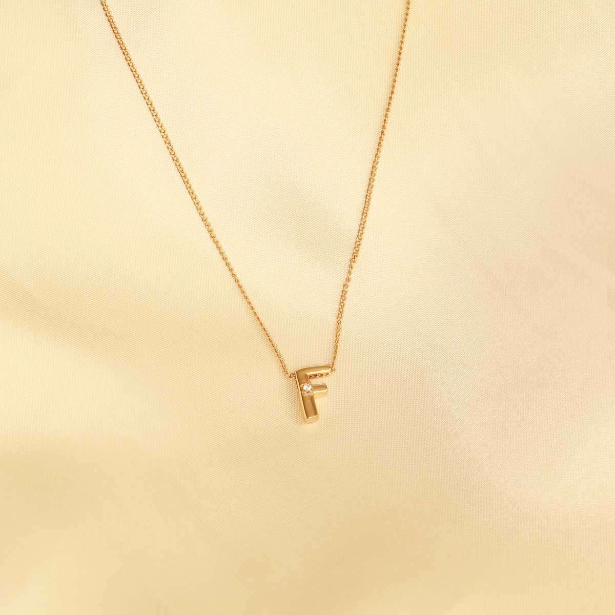 Flat lay shot of F Initial Pendant Necklace in Gold