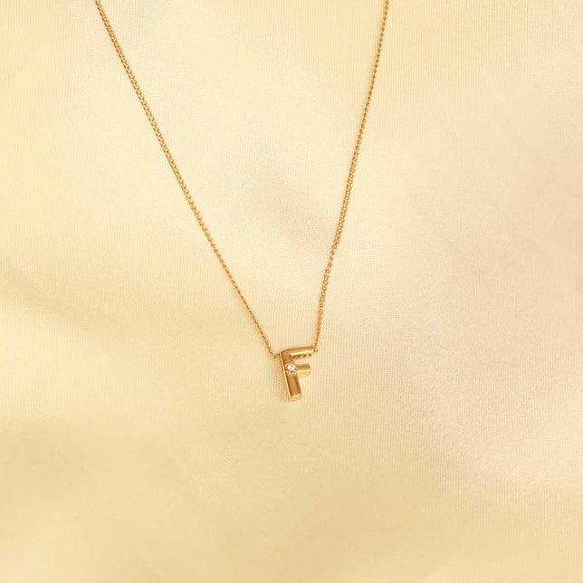 Flat lay shot of F Initial Pendant Necklace in Gold