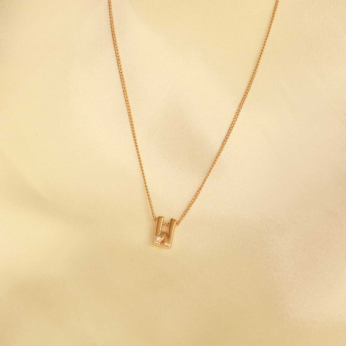 Flat lay shot of W Initial Pendant Necklace in Gold