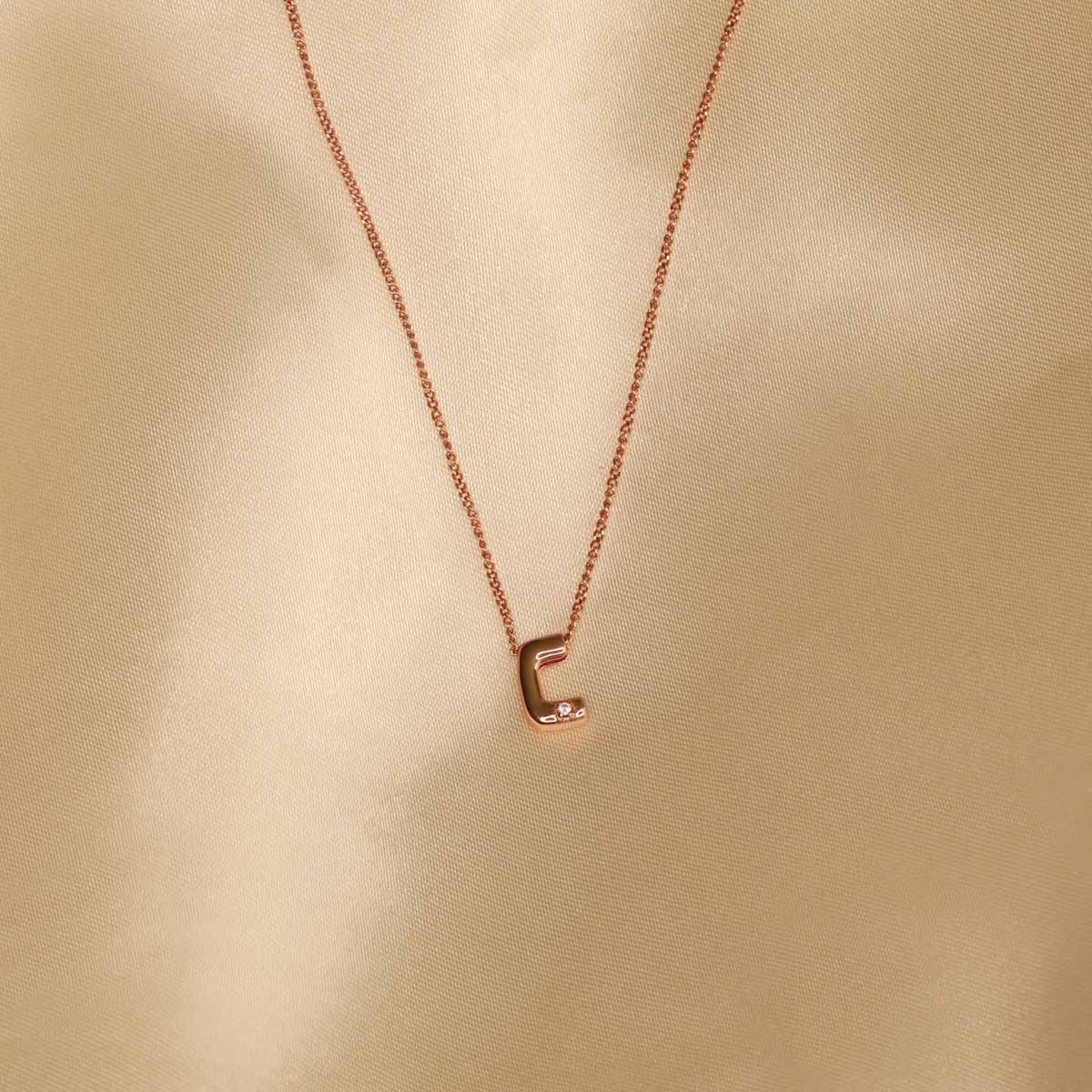 Flat lay shot of C Initial Pendant Necklace in Rose Gold