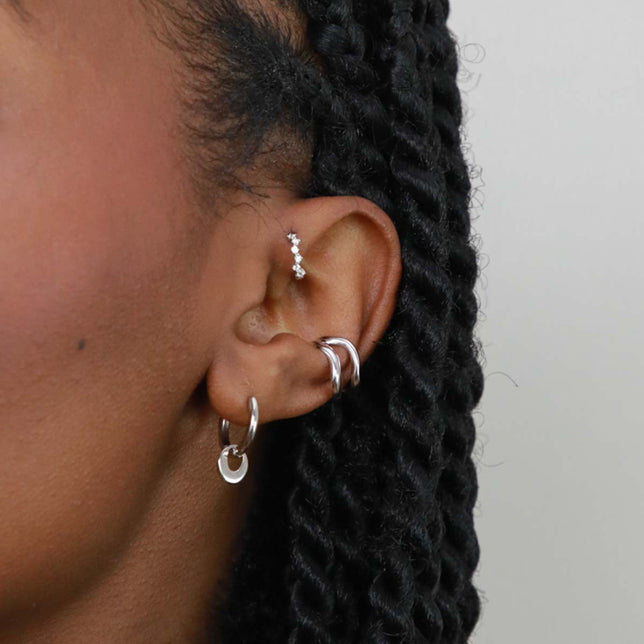 Worn shot of Molten Charm Hoops in Silver in front lobe piercing location