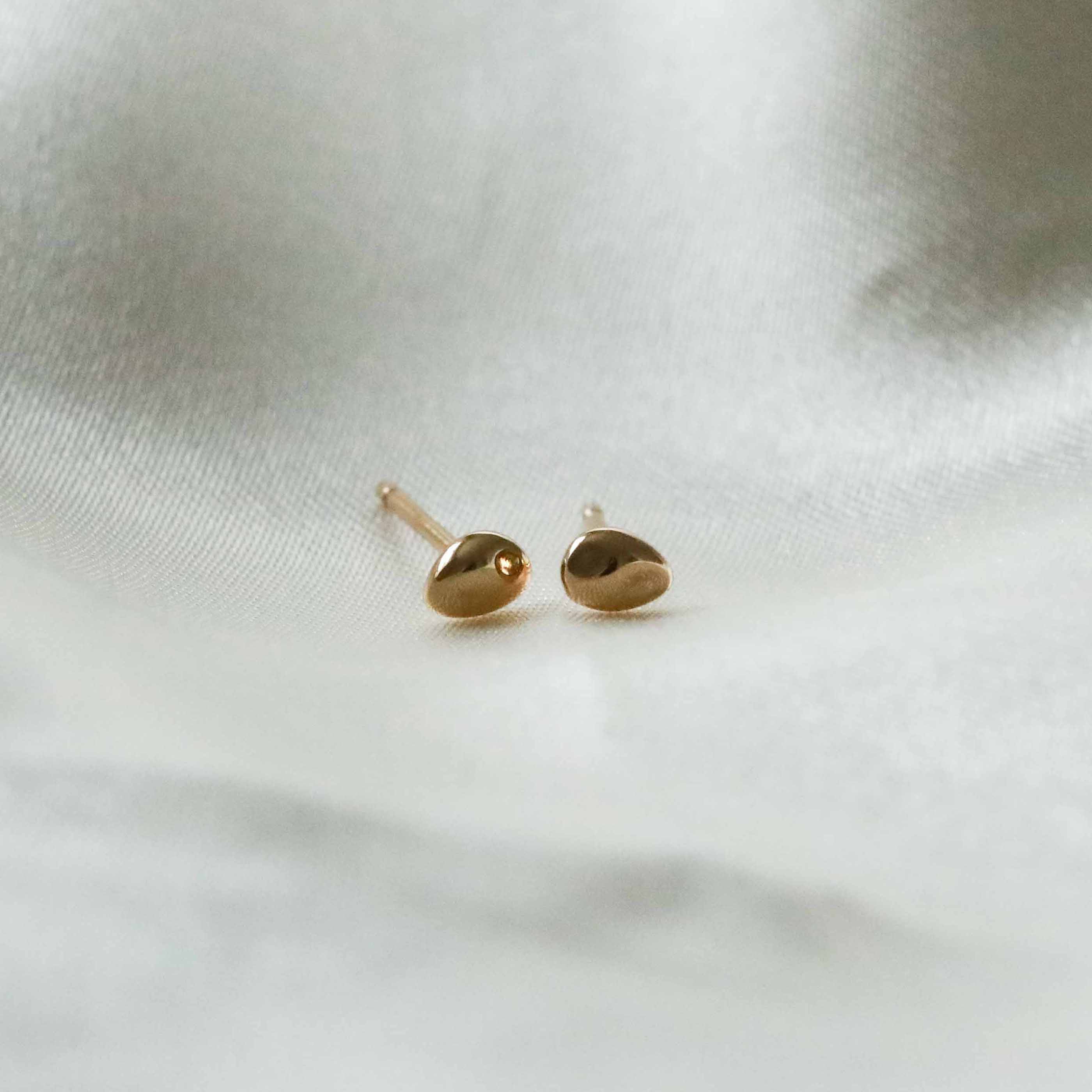 Flat lay shot of Molten Small Stud Earrings in Gold