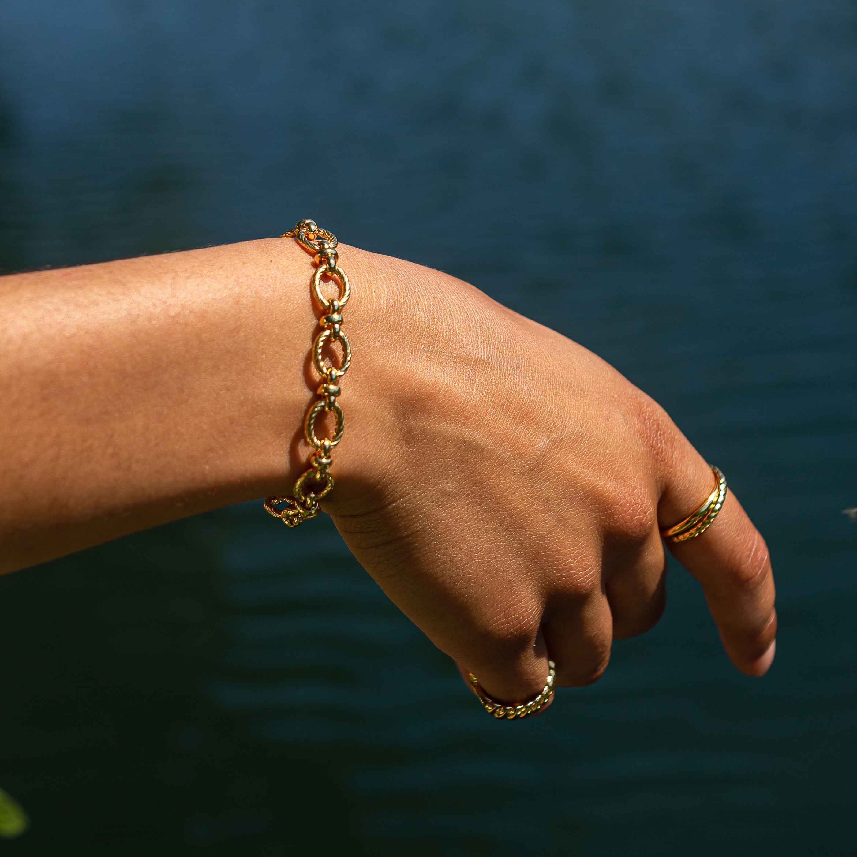 Textured Oval Link T-Bar Bracelet in Gold worn shot with rings