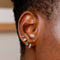 Flora Tiny Barbell in Silver worn in fourth lobe piercing