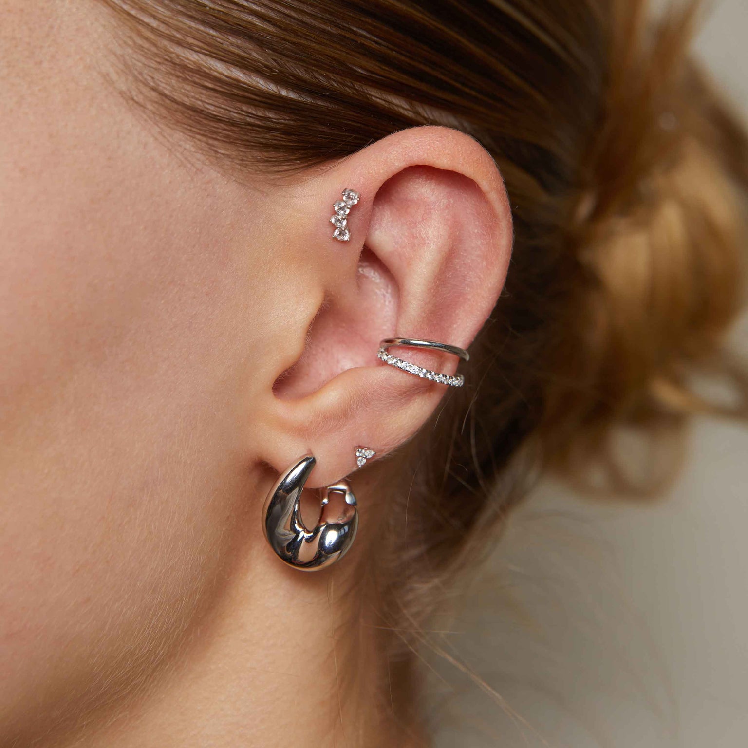 Triple Crystal Stud Earrings in Silver worn with illusion ear cuff